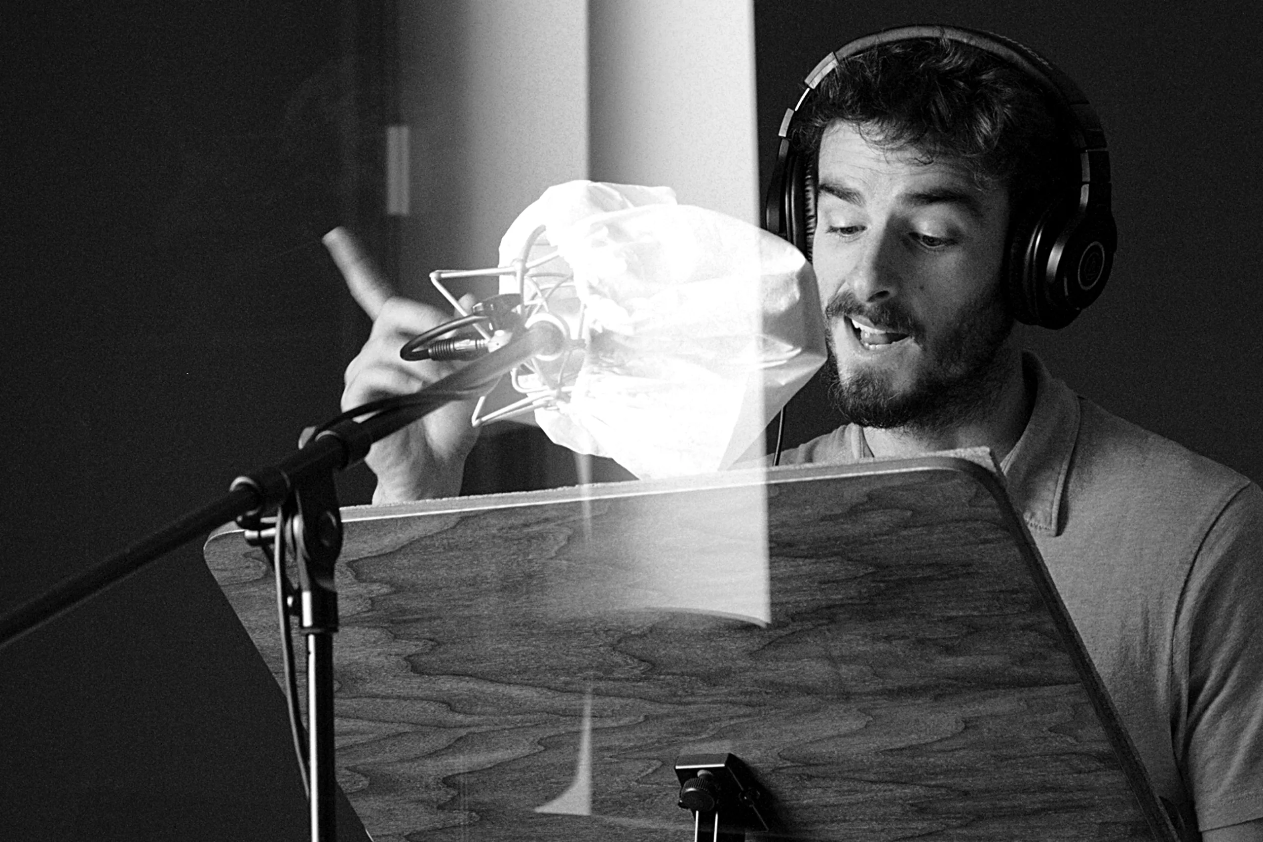 Luis Gustems, locutor y actor de doblaje, grabando en estudio con micrófono y auriculares